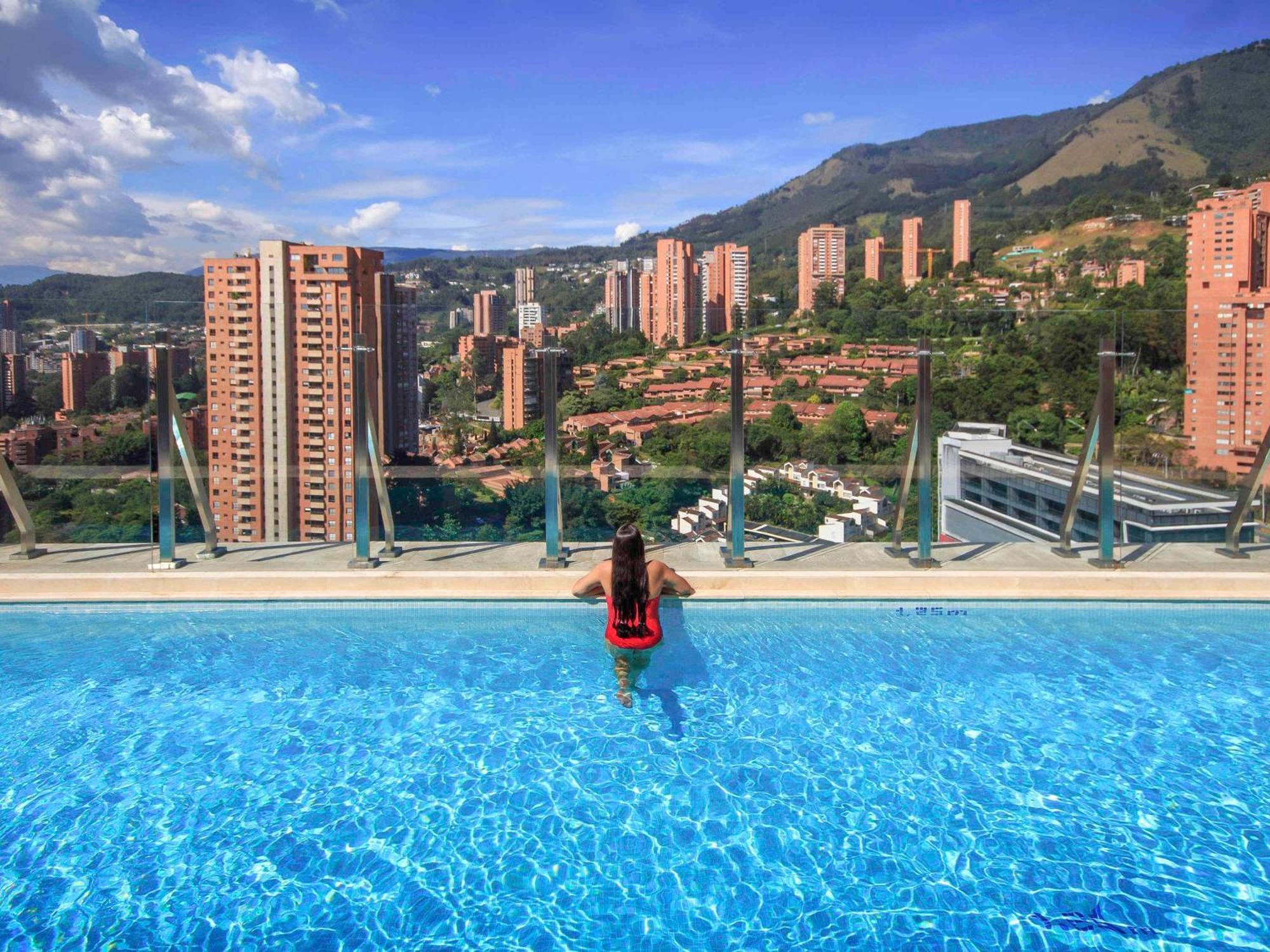 Novotel Medellín El Tesoro Exterior foto View of El Burgo from the swimming pool
